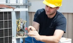 an electrician in backyard repairing the electrical wiring on an HVAC system